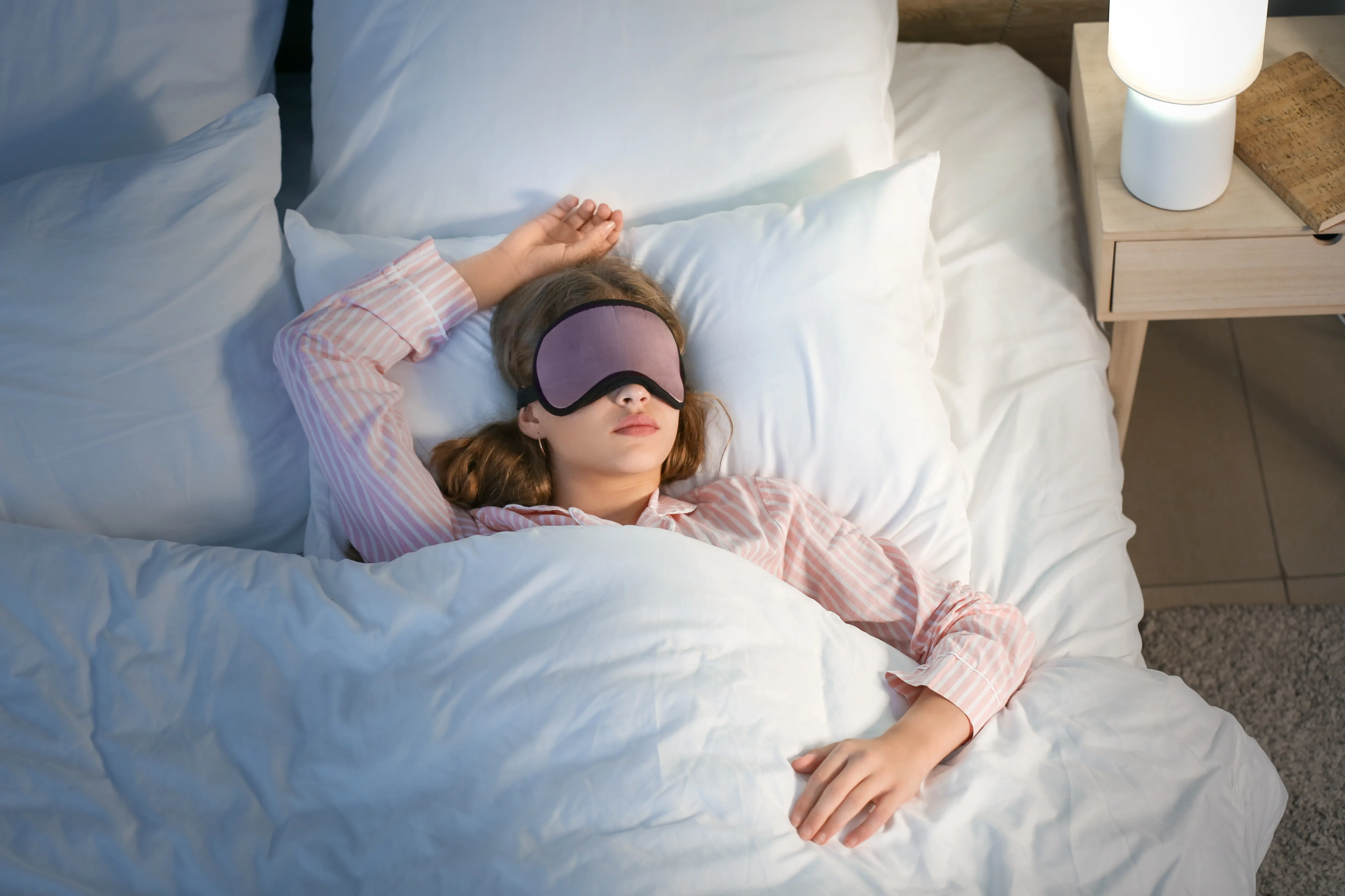 Frau im Bett mit Schlafmaske
