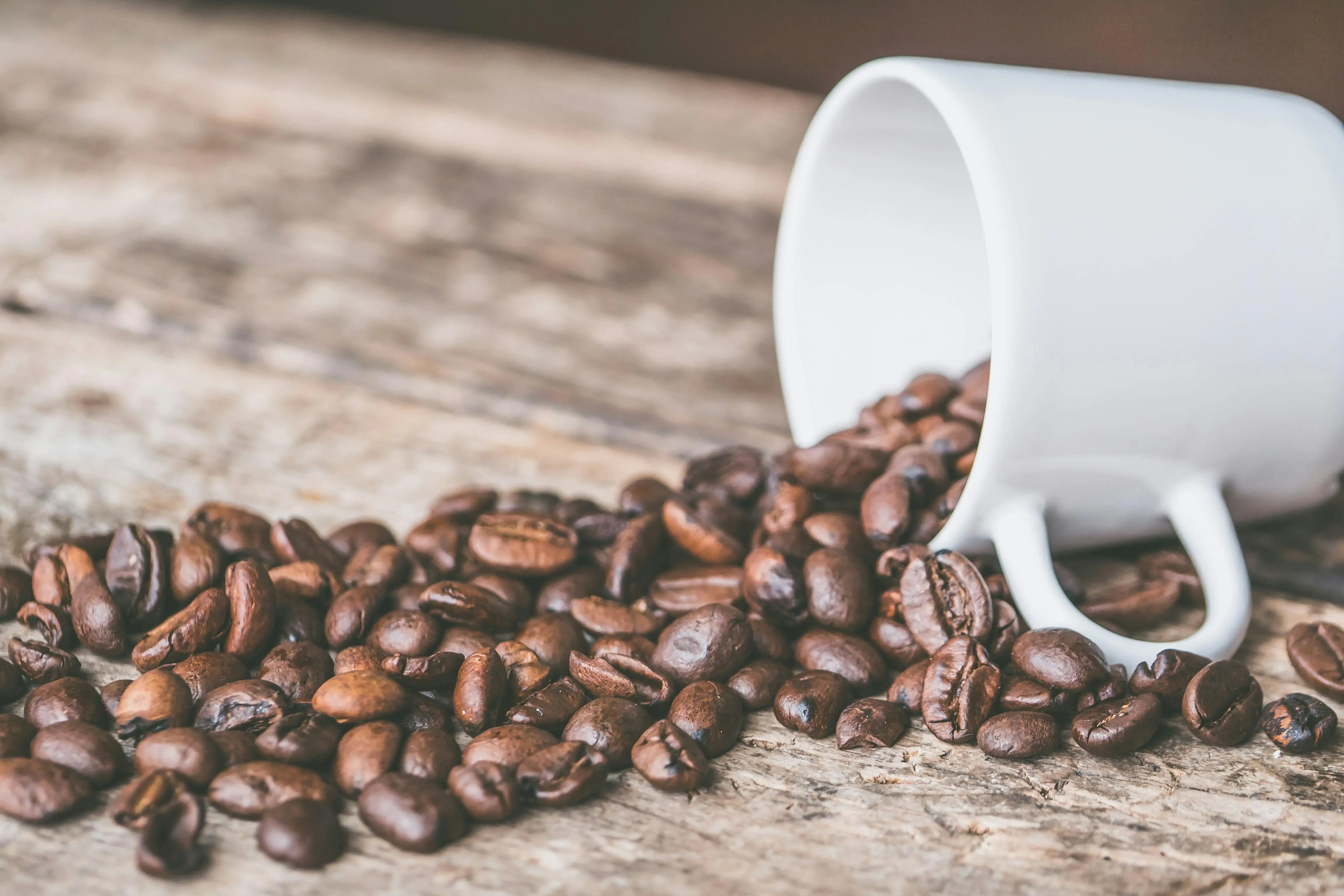 Kaffeebohnen und umgekippte Tasse